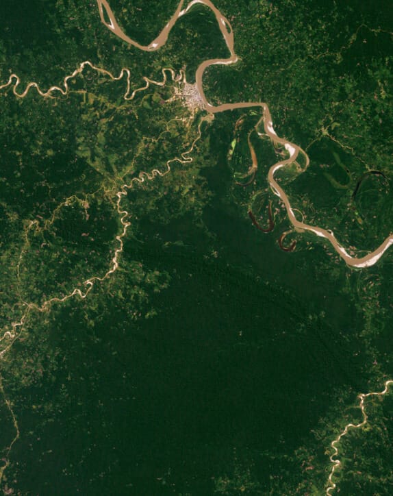 Aerial view of a river winding through a tropical forest landscape